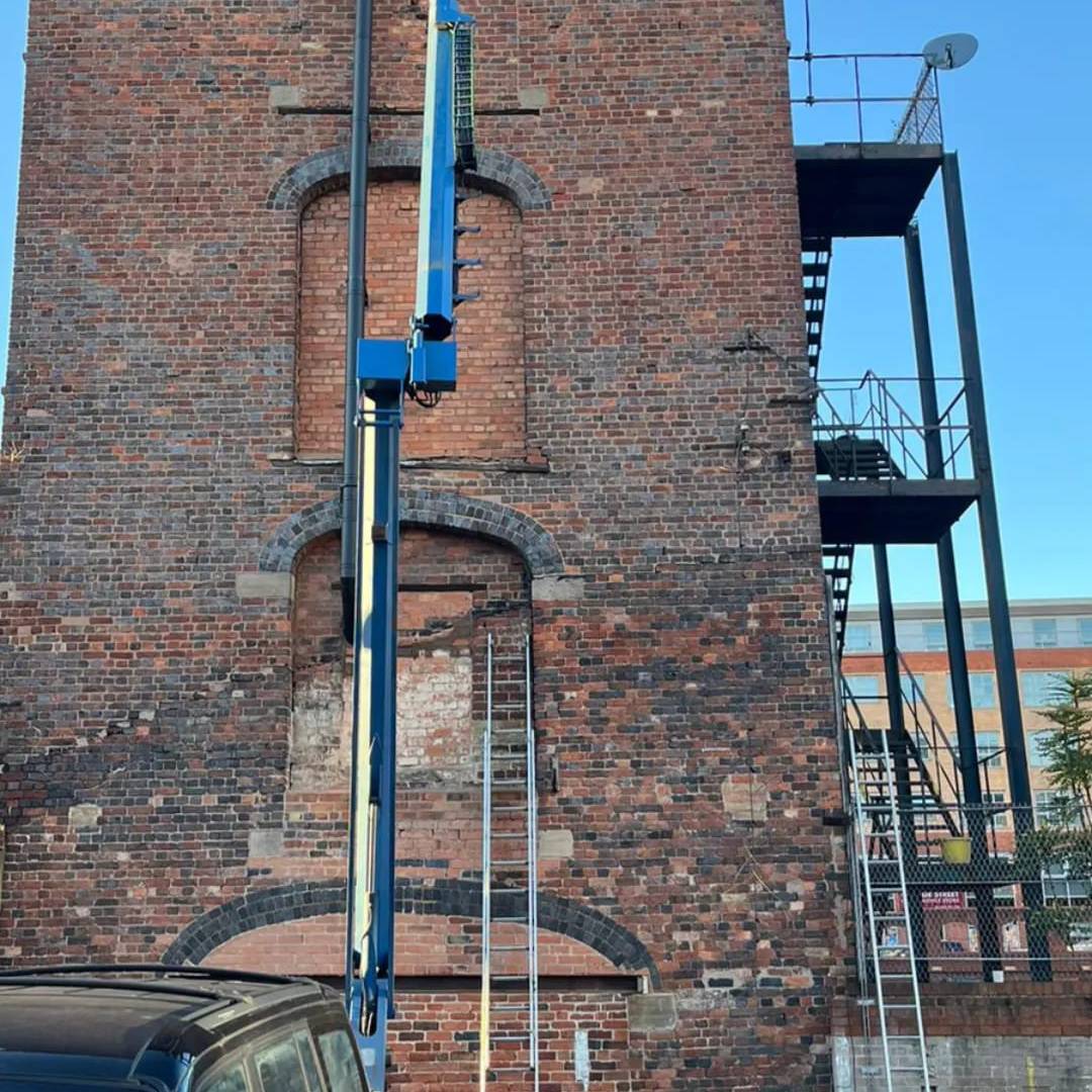 Nifty Lift Cherry Picker Trailer with cherry picker fully extended above multi storey heritage building