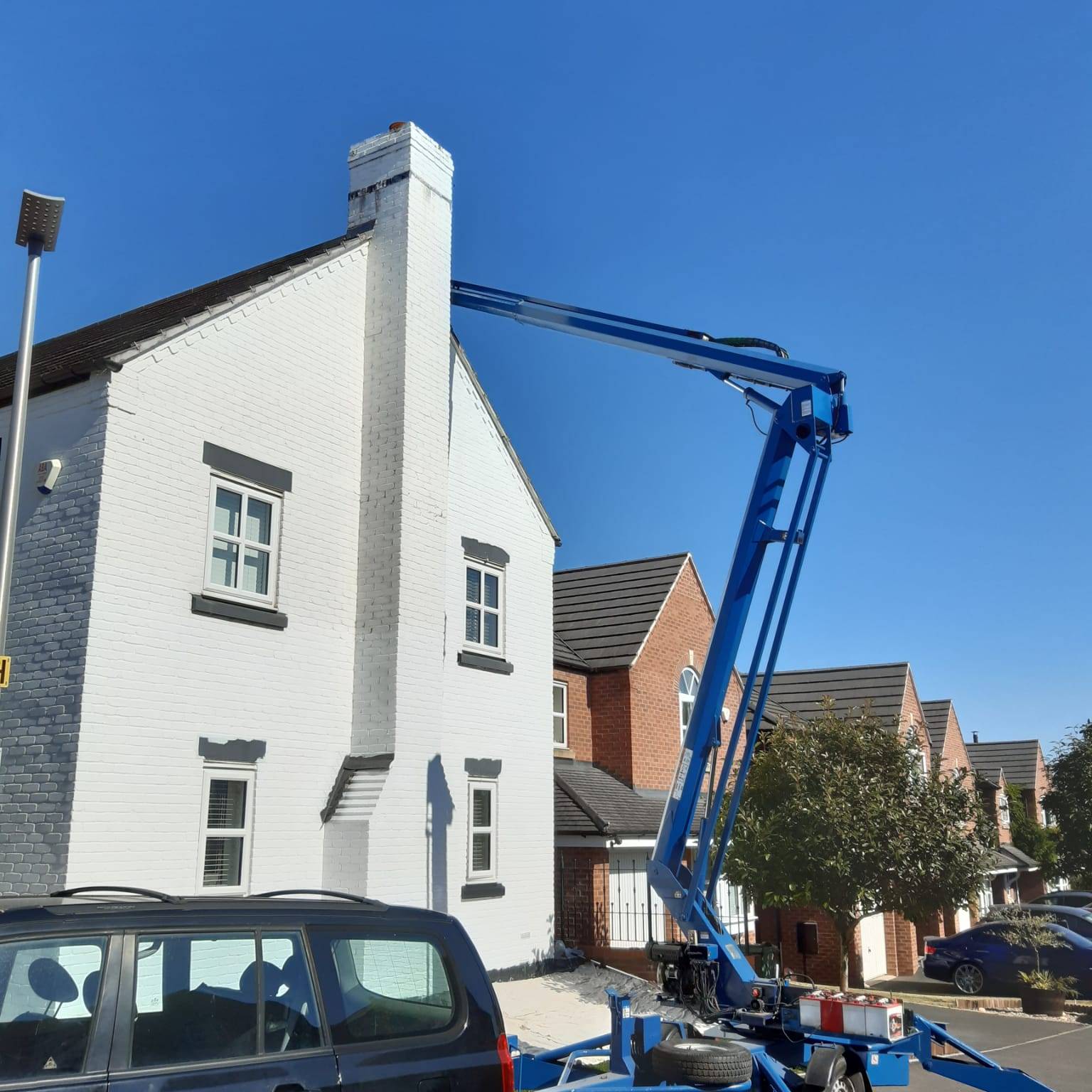 Photo of cherry picker reaching the ridge of a roof on a two storey building
