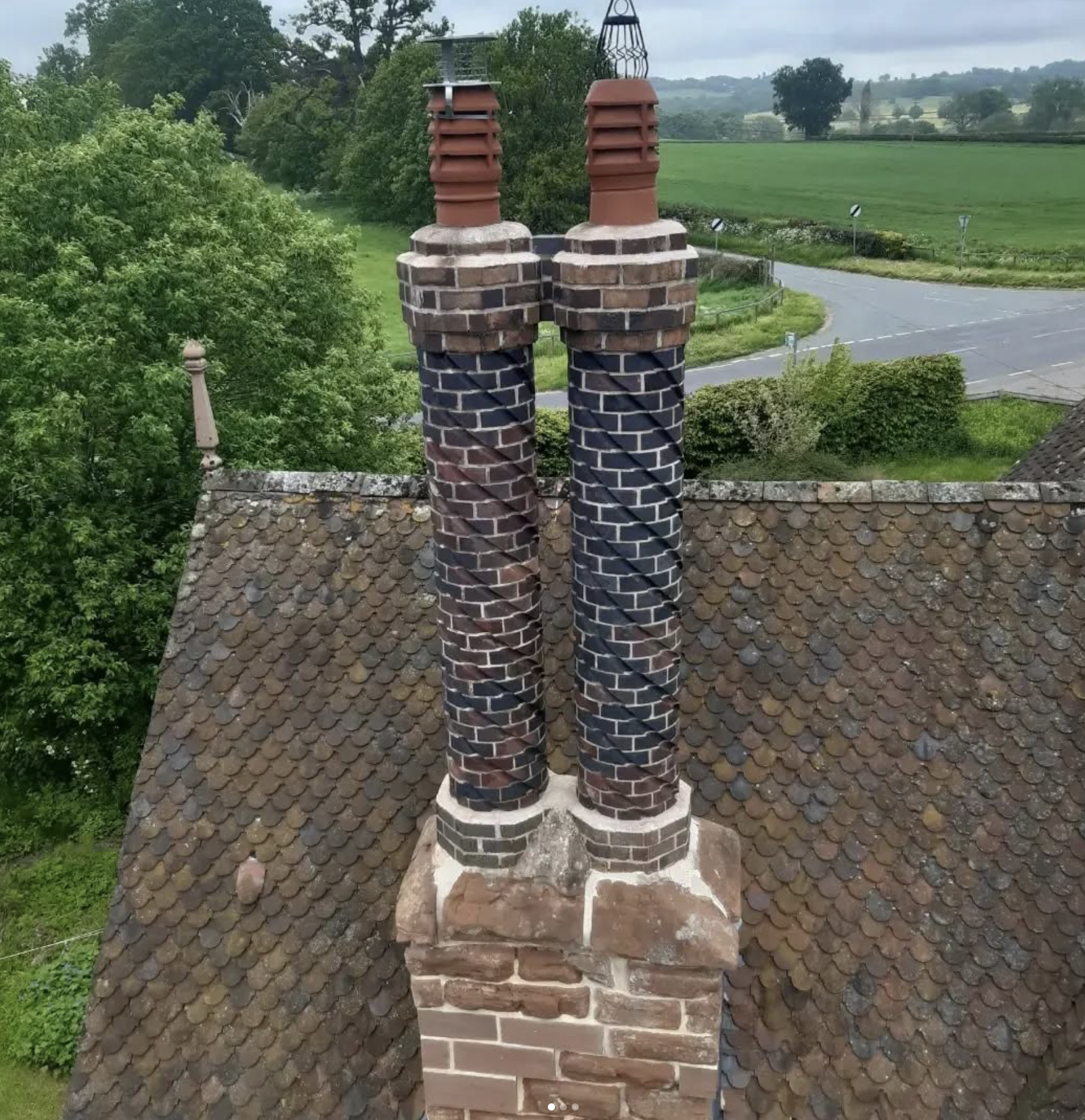 Photo of historic restored brick cylindrical round chimneys on roof